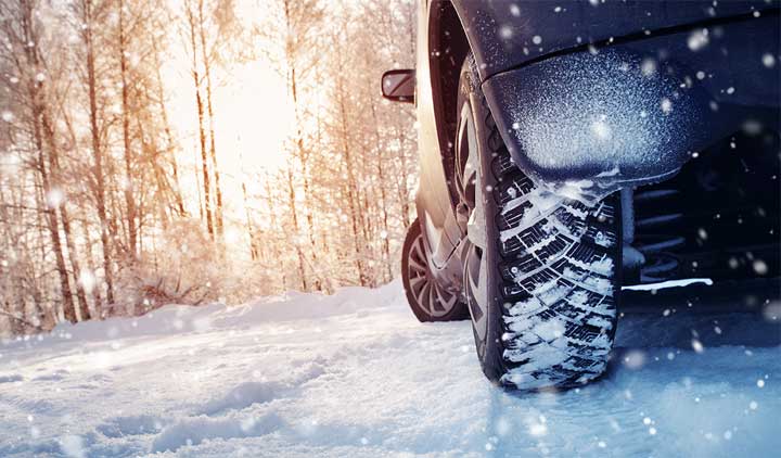 Auto fährt durch winterliche Landschaft.