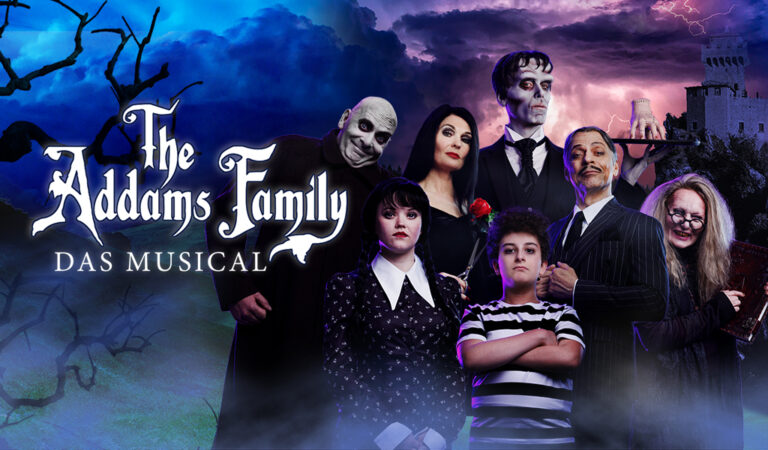 Die Addams Family posiert düster; alle in schwarzen Outfits vor einem nebligen, dramatischen Himmel.