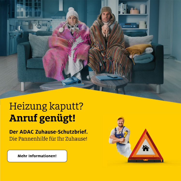 Zwei Personen, in Decken gehüllt, sitzen auf einem Sofa in einem gemütlichen Wohnzimmer.