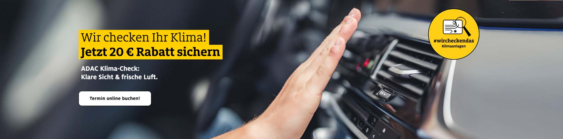 Eine Hand prüft die Klimaanlage in einem Auto mit modernem schwarzen Armaturenbrett.