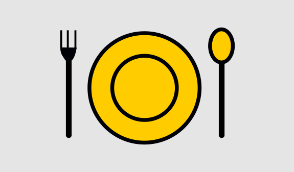 Ein gelber Teller mit schwarzem Rand, daneben eine schwarze Gabel und ein Messer