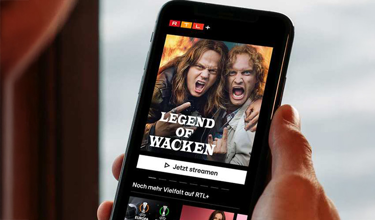 Zwei Männer mit langen Haaren posieren wild und schreien auf einem Handybildschirm