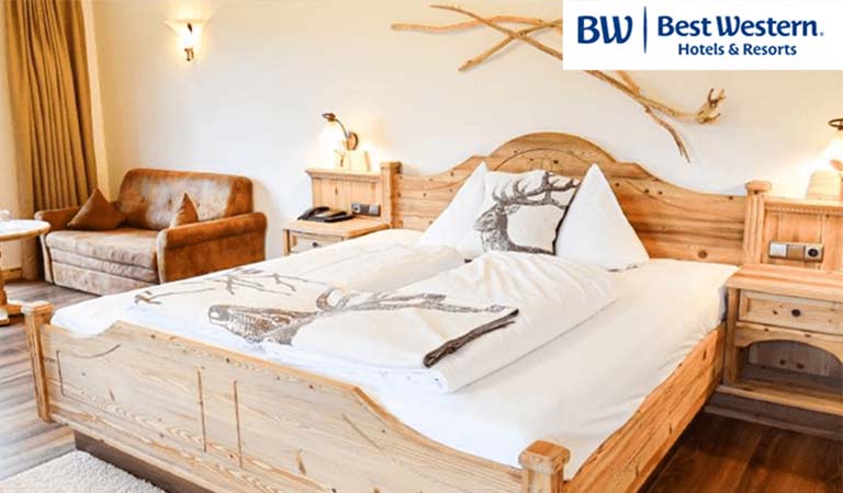 Ein gemütliches Hotelzimmer mit einem großen Holzbett und heller, warmer Einrichtung