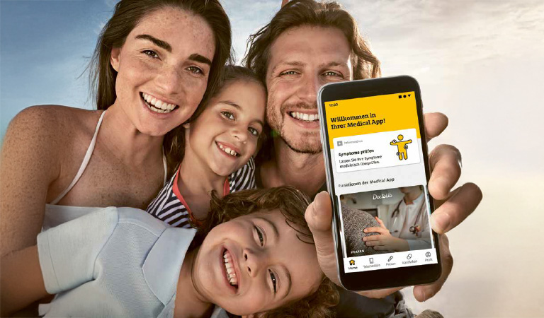 Eine fröhliche Familie macht ein Selfie im Freien, während ein Mann ein Handy zeigt