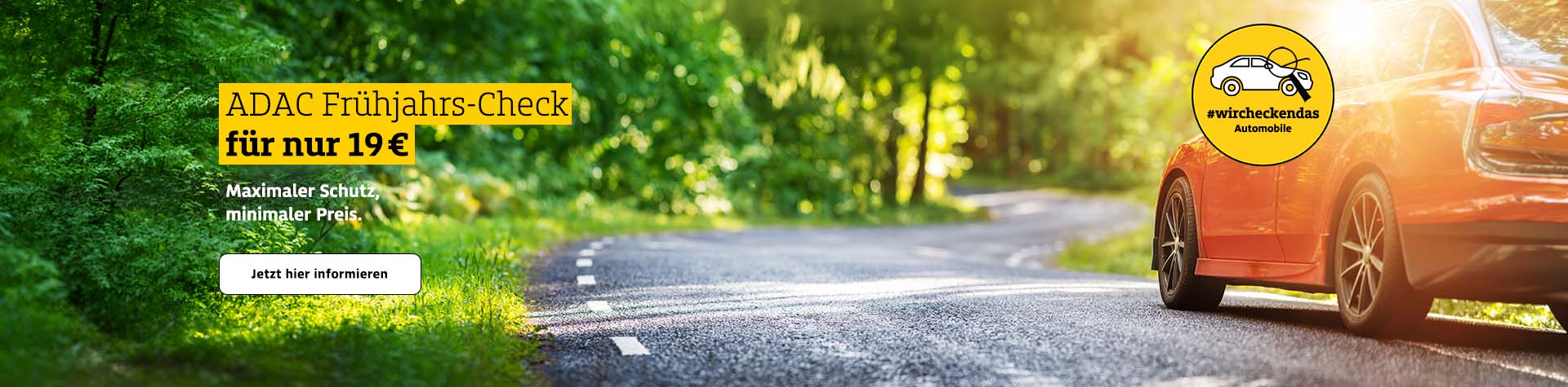 Ein rotes Auto fährt auf einer sonnigen Straße mit Bäumen im Hintergrund