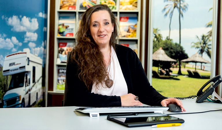 Eine Mitarbeiterin des ADAC Reisebüros Hagen lächelt in einem Reisebüro:  T. Lorenzen.