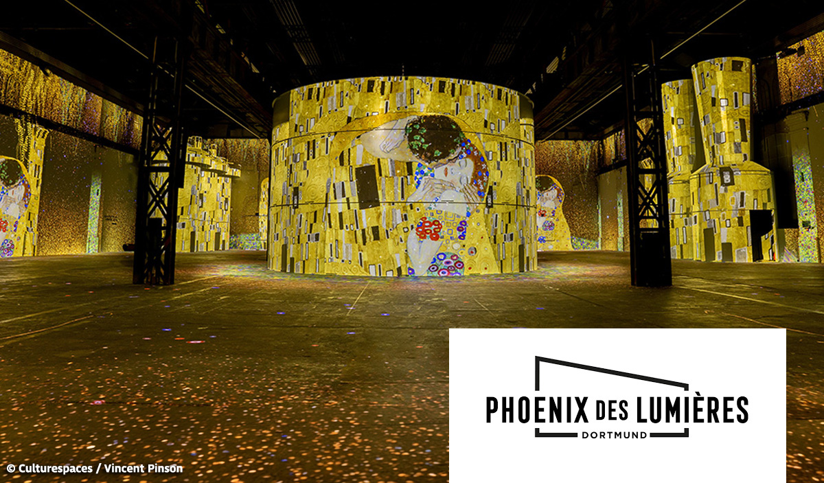 Eine große digitale Kunstinstallation mit goldfarbenen Lichtprojektionen und Gesichtern