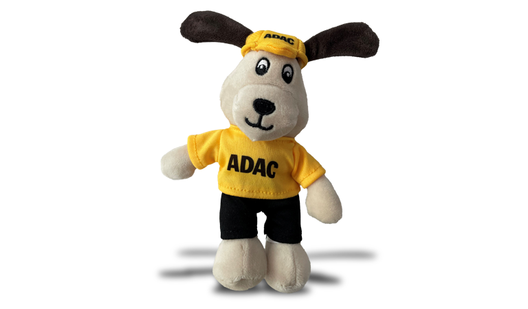 Plueschhund mit braunen Ohren und ADAC Shirt, freundlich und gelb gekleidet